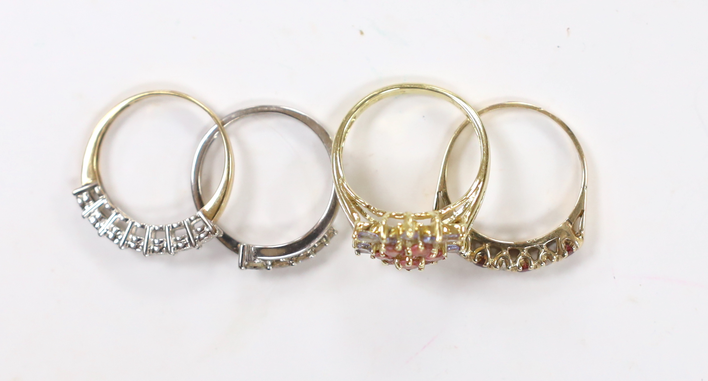 Four assorted modern 9ct gold and gem set rings (two with rubbed hallmarks), including seven stone illusion set diamonds chip and five stone graduated diamond chip